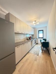 a kitchen with white cabinets and a table in it at Old Town Vinyl Retreat near the Cathedral with retro vibes in Iaşi