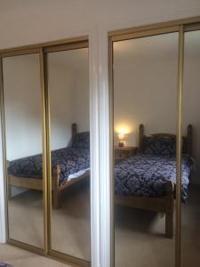 a bedroom with mirrored closets and a bed at An Teallach in Oban