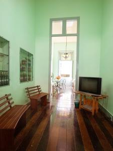 uma sala de estar com uma televisão de ecrã plano e bancos em Hostel Amazonia em Belém