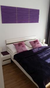 une chambre avec un lit avec des oreillers roses et blancs dans l'établissement Atrium Apartament, à Sarbinowo