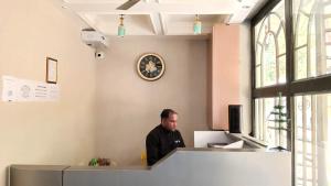 a man sitting at a counter in an office at Maheshwari international in Lansdowne