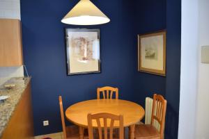 comedor con mesa de madera y sillas en Apartaments Bizantí, en Sant Martí d’Empúries
