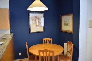 Un comedor con mesa y sillas de madera. en Apartaments Bizantí, en Sant Martí d’Empúries