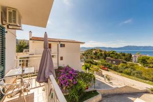 a balcony with purple flowers and an umbrella at Apartmani More in Gradac
