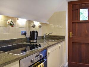 a kitchen with a sink and a stove top oven at Gwel An Lowarth in Lostwithiel