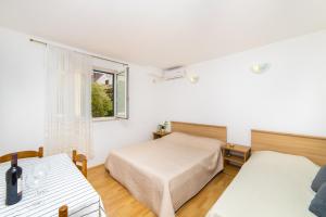 a bedroom with two beds and a window at Apartmani More in Gradac