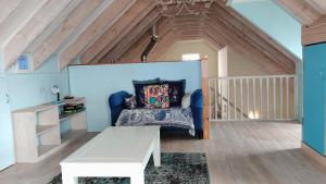 a living room with a blue couch and a table at Anchorage in Stompneusbaai +43 photos