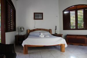 een slaapkamer met een bed met een knuffeldier erop bij Casa Atalaia in Pipa +32 foto's