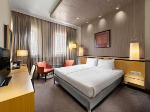 a hotel room with a bed and a desk at Mamaison Hotel Andrassy Budapest in Budapest