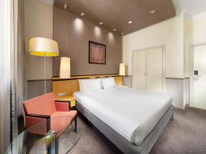 a hotel room with a bed and a chair at Mamaison Hotel Andrassy Budapest in Budapest