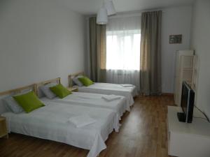 ジヴェエヴォにあるАпартаменты на Симанина 2のベッド2台とテレビが備わるホテルルームです。