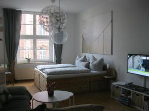 ein Wohnzimmer mit einem Bett und einem TV in der Unterkunft Zum Augustiner in Erfurt