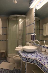 ein Bad mit einem Waschbecken, einem WC und einer Dusche in der Unterkunft CH-Hotel Luka in Wien