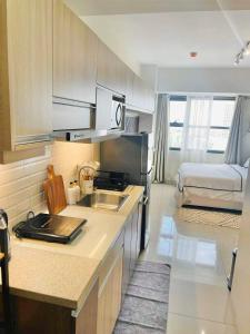 a kitchen with a sink and a bed in a room at Horizons 101 Studio unit near Fuente in Cebu City