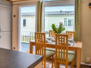 a dining room with a table and chairs and a large window at Lavender Lodge in Patrington