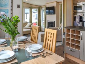 a kitchen and living room with a table and chairs at Lavender Lodge in Patrington