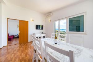 a dining room with a table and chairs and a window at Apartmani More in Gradac