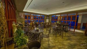 a dining room with tables and chairs and windows at Casa Marcos Resort and Villas in Pastrana