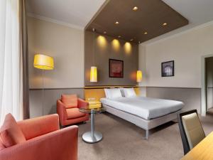 a hotel room with a bed and a table and chairs at Mamaison Hotel Andrassy Budapest in Budapest
