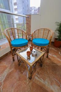 two rattan chairs and a coffee table in a room at Hotel Pi-Tapovan in Rishīkesh