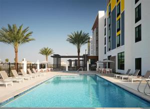 a swimming pool with lounge chairs and a building at Hilton Garden Inn Merced in Merced