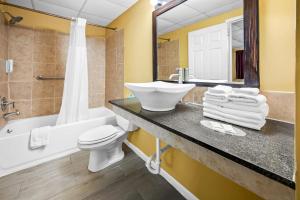 a bathroom with a sink and a toilet and a tub at Econo Lodge Gretna - New Orleans in Gretna +17 photos