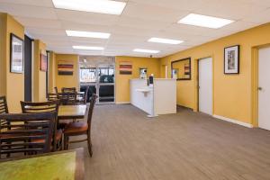 a dining room with yellow walls and tables and chairs at Econo Lodge Gretna - New Orleans in Gretna
