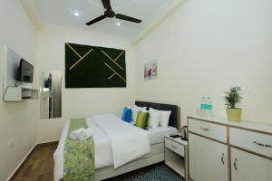 a bedroom with a bed and a ceiling fan at Hotel Pi-Tapovan in Rishīkesh