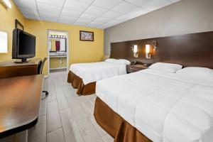 a hotel room with two beds and a flat screen tv at Econo Lodge Gretna - New Orleans in Gretna