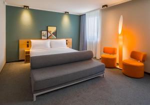 a bedroom with a bed and a desk and a chair at Spark by Hilton Wuppertal City Centre in Wuppertal +104 photos
