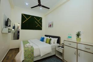a bedroom with a bed and a ceiling fan at Hotel Pi-Tapovan in Rishīkesh +32 photos