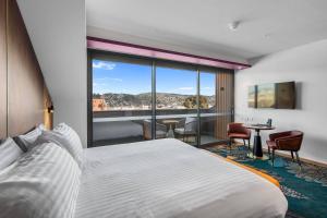 a hotel room with a bed and a large window at George Hotel Launceston, an Ascend Collection Hotel in Launceston +42 photos
