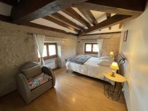 a bedroom with a bed and a chair in a room at Chambres d’hôtes Le relais de Mantelot in Châtillon-sur-Loire
