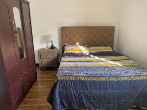 a bedroom with a bed and a dresser with a lamp at CasaOlivia in Puerto Galera