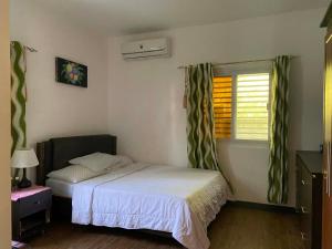 a small bedroom with a bed and a window at CasaOlivia in Puerto Galera
