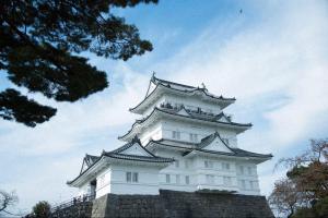 a tall white building with a roof at Tipy records inn photon in Odawara