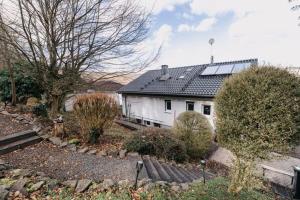 a white house with solar panels on top of it at Ferienhaus Waldzeit in Heimbach