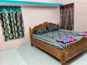 a bedroom with a wooden bed and curtains at Sumathinandanakuteer in Pithāpuram