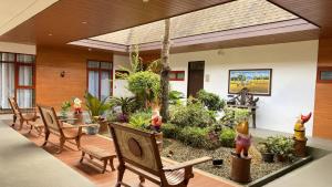 a room with chairs and a garden with plants at Casa Marcos Resort and Villas in Pastrana