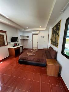 a room with a bed and a couch and a desk at Ban Elephant Blanc Apartment in Kata Beach