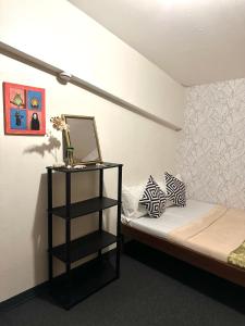a small bedroom with a bed and a shelf at Amancio's Tourist Inn-Close to the Airport in Puerto Princesa City