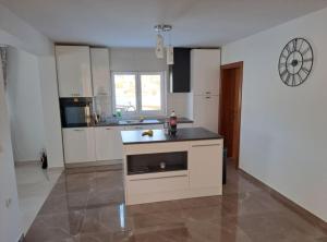 a kitchen with white cabinets and a black counter top at Apartment Freya in Zadoborje