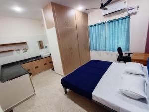 a bedroom with a blue and white bed and a desk at RV Comforts in Perambalūr
