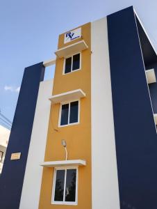 a yellow and white building with a sign on it at RV Comforts in Perambalūr