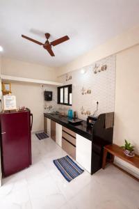 a kitchen with a black counter and a ceiling fan at The Calm Courtyard- Pune in Pune