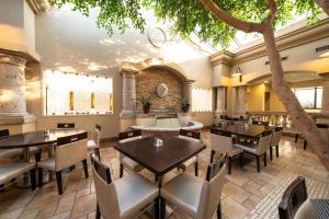 a restaurant with tables and chairs and a tree at DoubleTree by Hilton Hotel Houston Hobby Airport in Houston
