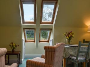a room with a table and chairs and windows at Gwel An Lowarth in Lostwithiel