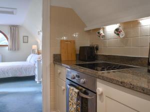 a kitchen with a stove top oven next to a bed at Gwel An Lowarth in Lostwithiel
