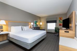 a hotel room with a bed and a flat screen tv at Hampton Inn & Suites Port St. Lucie in Port Saint Lucie