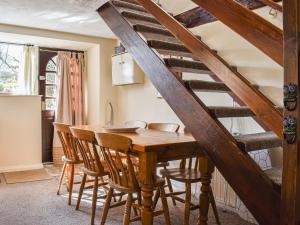 a dining room with a wooden table and chairs at Meadow Cottage in Leek
